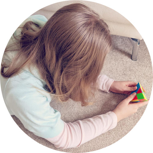 Jenna Breunig working on a pyraminx (a pyramid Rubik's cube) with her face hidden